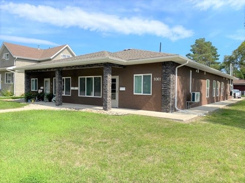 a brown house with a lawn in front of it